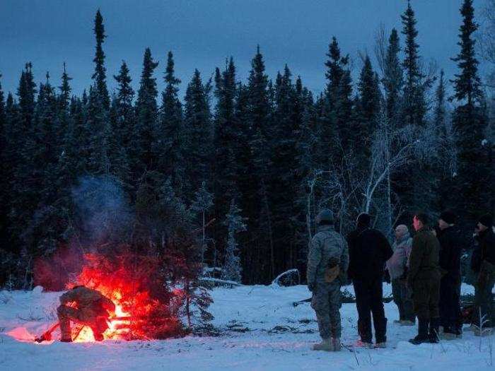 Another vital principal of survival students learn is how to create an effective signal fire by placing a flare inside a base of kindling and smoke-generating tree limbs.