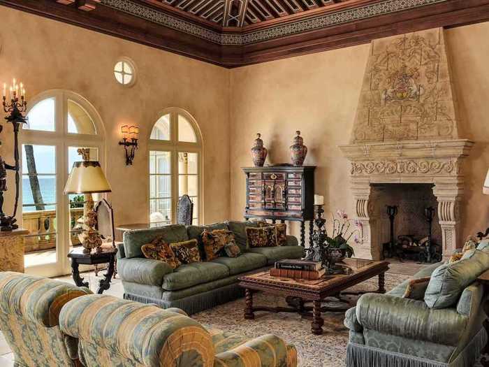 The living room features a custom carved stone fireplace and a custom carved wooden ceiling.