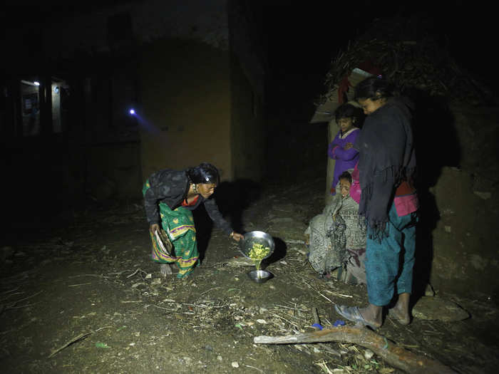 Here, a family member offers food to women practicing chaupadi. The person who brings the food should not touch the dish, because menstruating women are considered "untouchable."