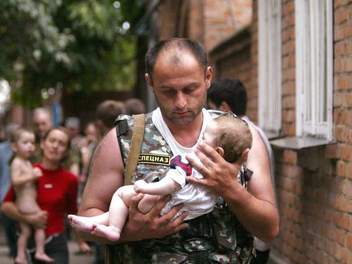 A Russian police officer carries a released baby from a school seized by heavily armed masked men and women in the town of Beslan in the province of North Ossetia near Chechnya in 2004.