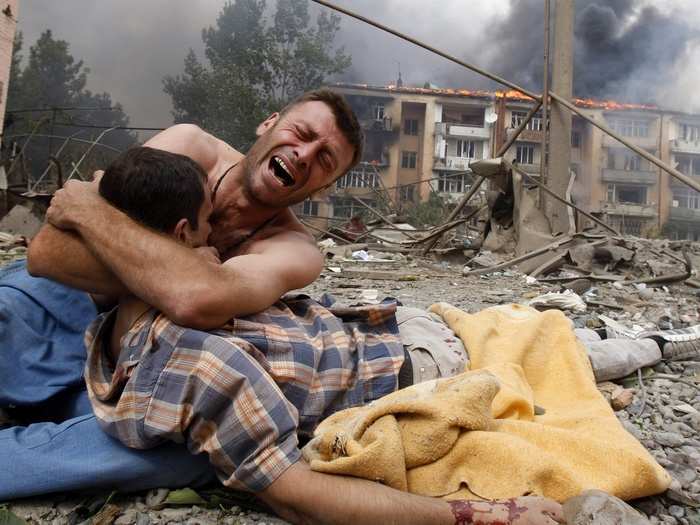 A Georgian man cries as he holds the body of his relative after a bombardment in Gori, 50 miles from Tbilisi in August 9, 2008.