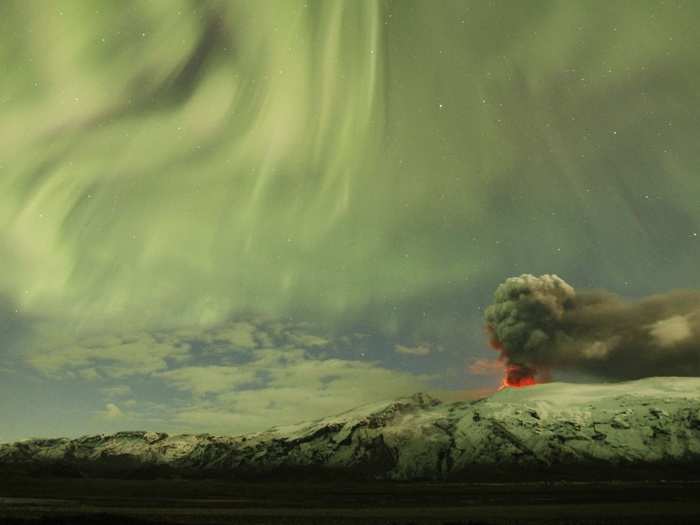 The Northern Lights are seen above the ash plume of Iceland