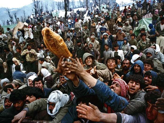 Frantic Kurdish refugees struggle for a loaf of bread during a humanitarian aid distribution at the Iraqi-Turkish border in this April 5, 1992 photo.