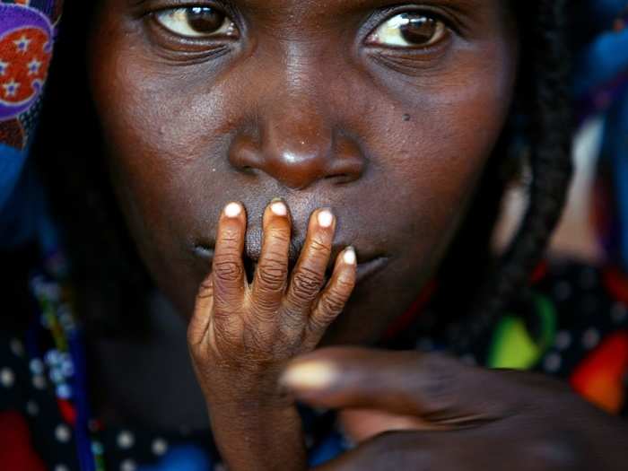 The fingers of malnourished one-year-old Alassa Galisou are pressed against the lips of his mother Fatou Ousseini at an emergency feeding clinic in the town of Tahoua in northwestern Niger, in this August 1, 2005 photo.