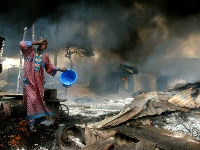 A man rinses soot from his face at the scene of a gas pipeline explosion near Nigeria