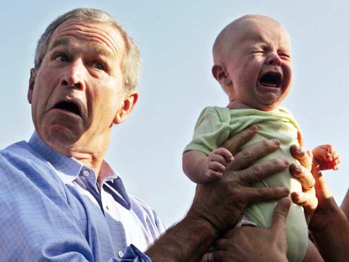 U.S. President George W. Bush hands back a crying baby that was handed to him from the crowd as he arrived for an outdoor dinner with German Chancellor Angela Merkel in Trinwillershagen, Germany in July, 2006.