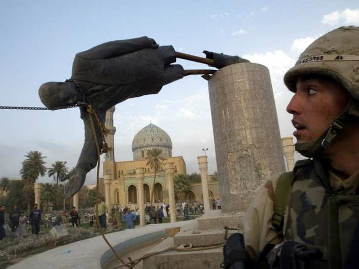 U.S. Marine Corp Assaultman Kirk Dalrymple watches as a statue of Iraq