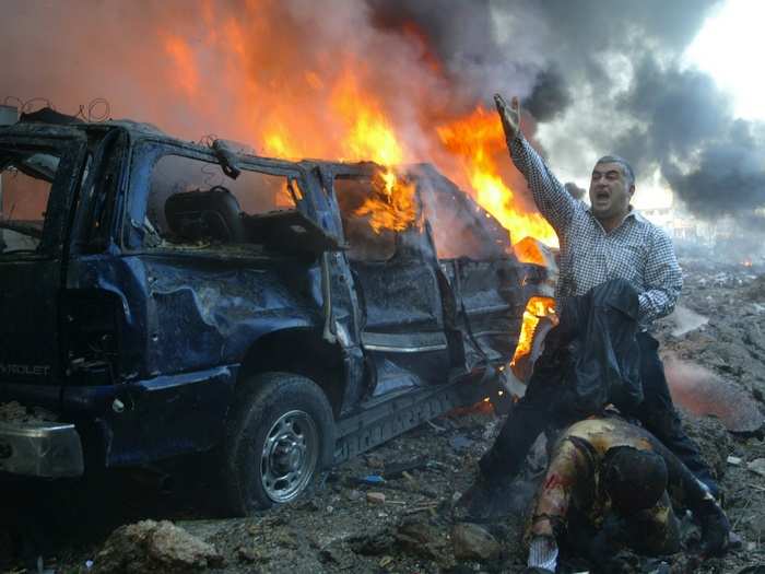 A Lebanese man shouts for help for a wounded man near the site of a car bomb explosion in Beirut in this February 14, 2005 photo. A massive car bomb killed Lebanon