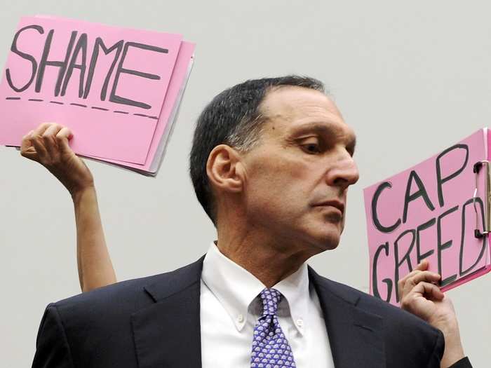 Protestors hold signs behind Richard Fuld, Chairman and Chief Executive of Lehman Brothers Holdings, as he takes his seat to testify at a House Oversight and Government Reform Committee hearing on the causes and effects of the Lehman Brothers bankruptcy, on Capitol Hill in Washington in October, 2008. Fuld told Congress that U.S. banking regulators knew exactly how Lehman was pricing its distressed assets and about its liquidity in the months before its collapse.