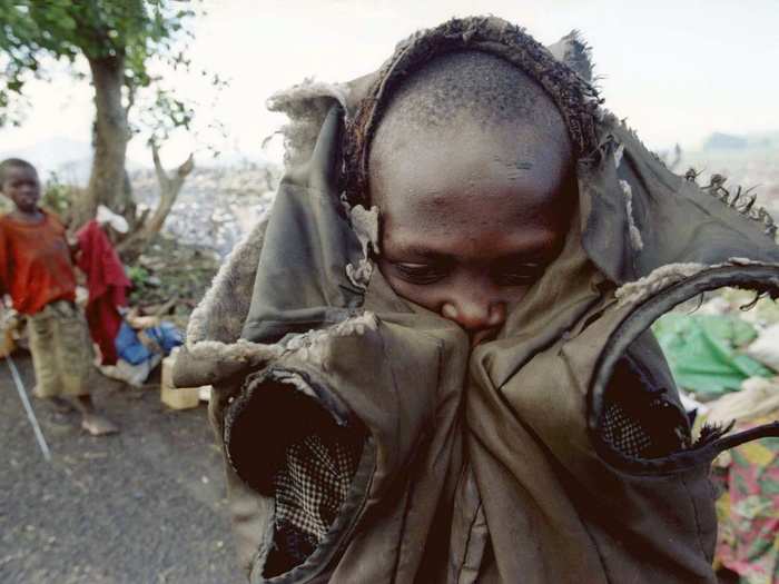 A young Rwandan refugee who traveled from Bukavu with several thousand others shivers in the early morning in this November 1996 photo before getting back on the road to the border. He was part of a group of some 20,000 refugees, many suffering from disease and malnutrition, who had made their way into Goma after being on the road for over one month.