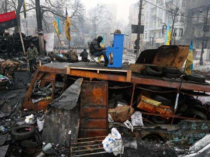 A Ukrainian protester plays piano on a barricade in front of the riot police line during the Euromaidan protests in Ukraine.