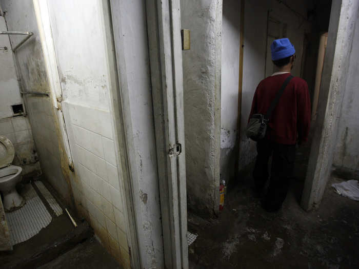 Ng, 60, leaves a communal toilet near his 60-square-feet subdivided apartment inside an industrial building in Hong Kong. Ng pays a monthly rent of HK$1,250 ($161) for the flat. Subdividing flats is often illegal and can lead to safety and sanitary concerns if not handled correctly.