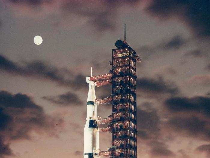 View of the giant Saturn V rocket on the pad at dawn with the Moon in background, November 9, 1967. Apollo 4 was the first, unmanned test flight of the Saturn V launch vehicle.