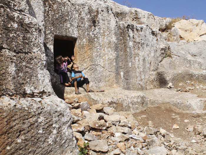 A Syrian family is pictured outside a cave they fled to in fear of shelling, at the Al-Arbaeen mountain in Idlib province.