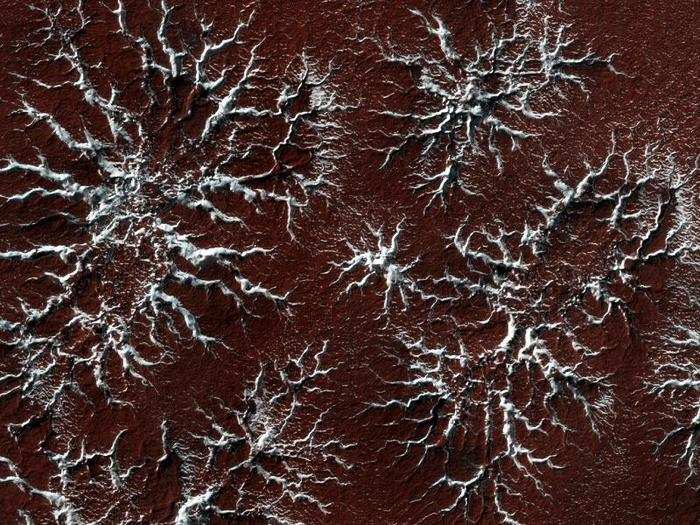 When temperatures heat up in the Spring, the carbon-dioxide ice in the polar caps sublimates into the atmosphere leaving behind these distinct starburst patterns. Why the melting process makes these characteristic patterns is a subject of ongoing research.