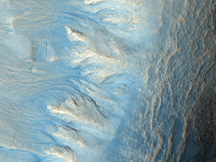 The gullies in the left of this image are a topic of much debate. Scientists suspect that they either formed from flowing water, liquid carbon dioxide, or something else. There