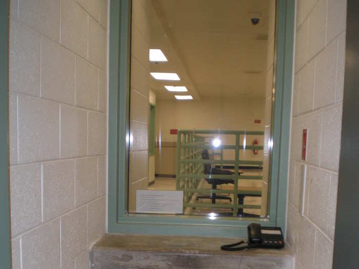 During social visits, inmates use a telephone to communicate through a glass pane. Guards may shackle their ankles the entire time.