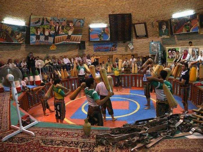 This is an exercise club in Yazd where men swing clubs to build strength. The club is built inside a water reservoir, cooled by wind towers.