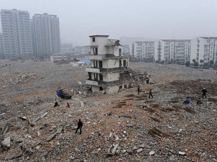 Here, a partly demolished home stands at a construction site in Hefei in 2010.