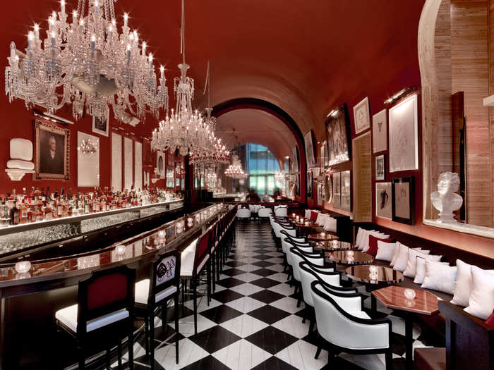 The second-floor bar, aptly named The Bar, draws inspiration from the American saloons of decades past and the royal stables at Versailles, from the natural-wood walls to the black-and-white checkerboard floors.