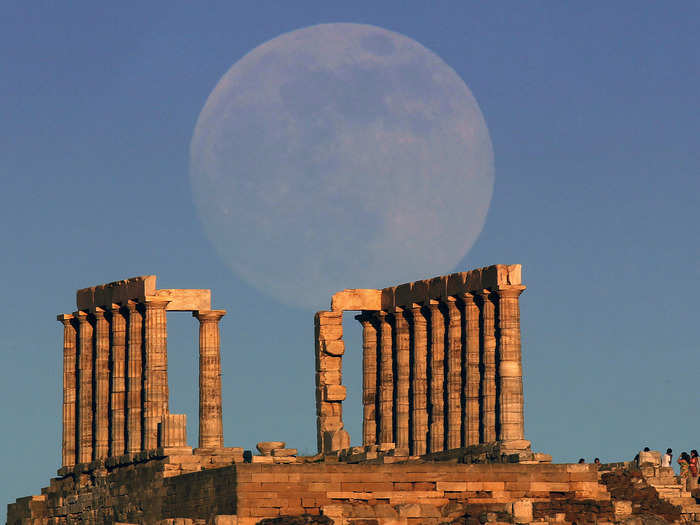 The supermoon rises over the temple of Poseidon, the ancient Greek god of the seas, in Cape Sounion, Greece.