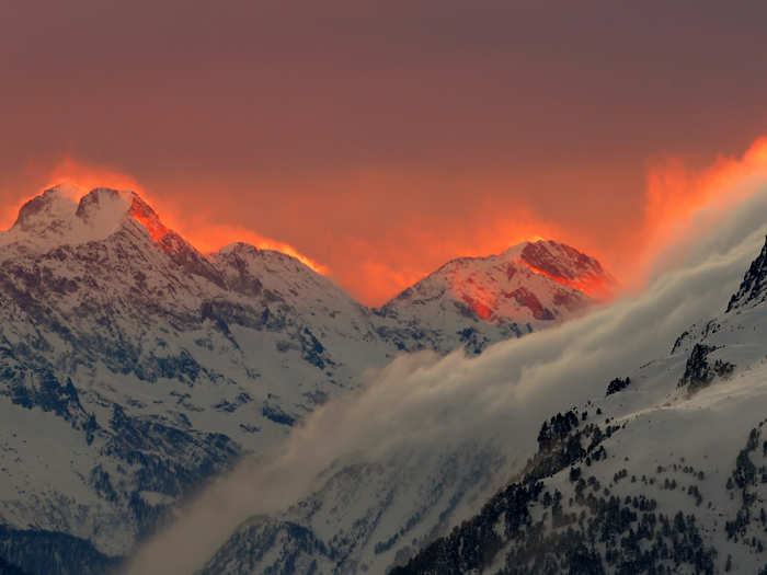 The sunset lights up mountains near a Swiss resort.