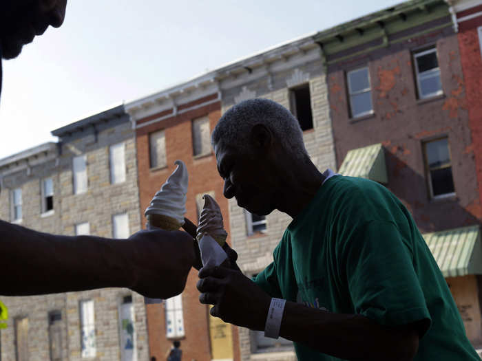 More than 30,000 people in Baltimore experience homeless in a given year. Some choose shelters; other become squatters on abandoned properties. In the picture below, two homeless men eat ice cream cones across the street from a block of vacant row houses.