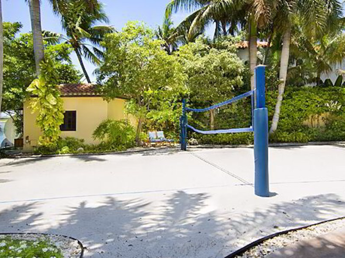 A regulation-size beach volleyball court stands to one side.