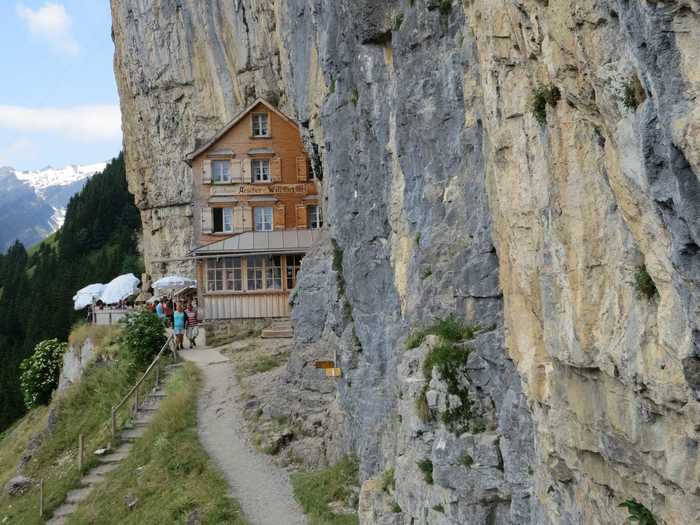 Enjoy the spectacular views at the Berggasthaus Aescher guesthouse, which is nestled in a mountain in the Swiss Alps.