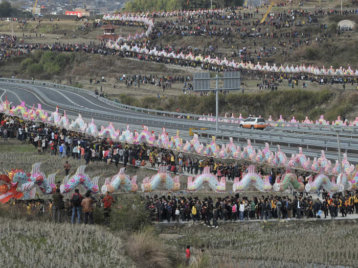 Villagers perform the annual "dragon march" to celebrate the Lantern Festival in Gutian township, China, on February 6, 2012. The marching dragon, made of paper and bamboo and connected by wood planks, set the new Guinness World Records of the longest parade float with 2596.8 feet, according to local media.