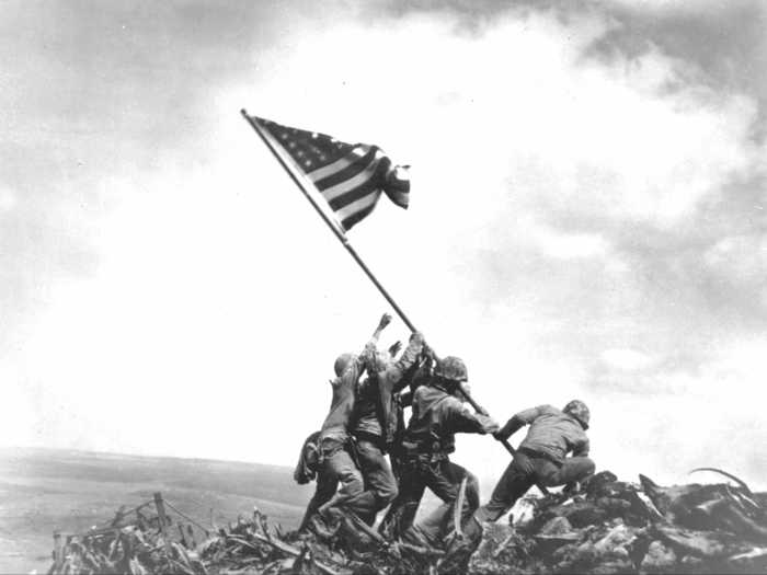 Marines raise the American flag at the summit of Mt. Suribachi during the battle for Iwo Jima in 1945. This enduring image is actually of the second flag raised on the mountain that day. The first flag was taken down because it was too small to be seen easily.