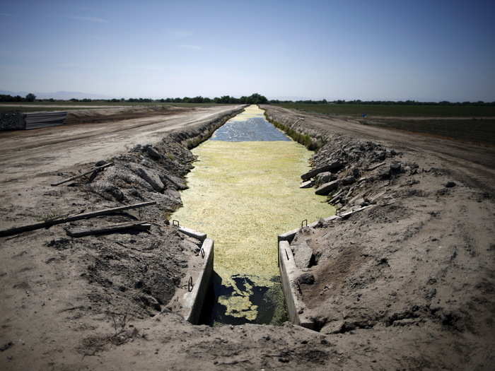 A canal runs through dwindling farm fields in Los Banos.