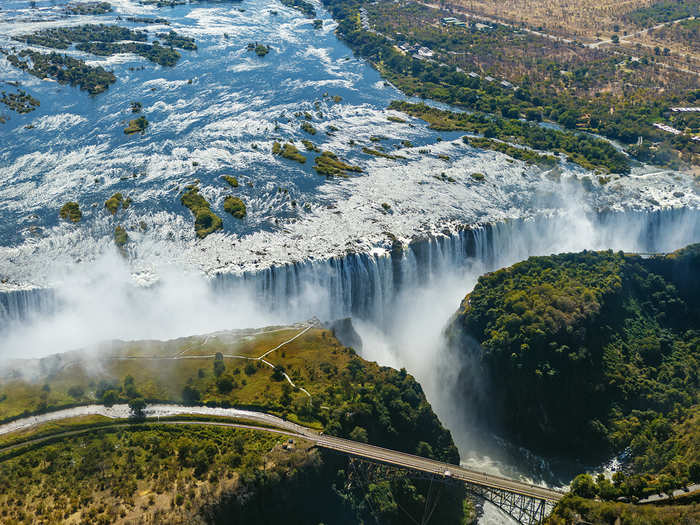 Victoria Falls, known as "The Smoke that Thunders," purges more than 500 cubic meters of water per minute into the gorge below. The waterfall forms the border between Zambia and Zimbabwe, and columns of spray can be seen from miles in either direction. Bungee jumping, zip-lining, white water rafting, and helicopter flights are available on site.