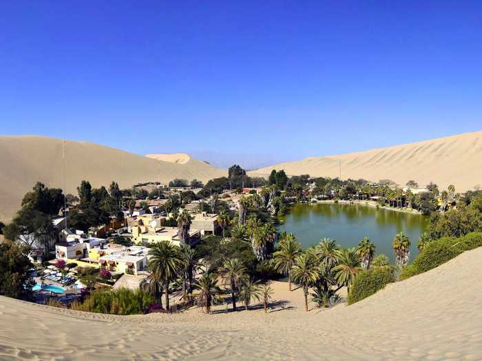 The resort town of Huacachina is a literal oasis in the Peruvian desert. Built around a small, natural lake in the Southwestern Ica Region, Huacachina is popular for tourists who want to try "sandboarding" on the massive dunes surrounding the lake.