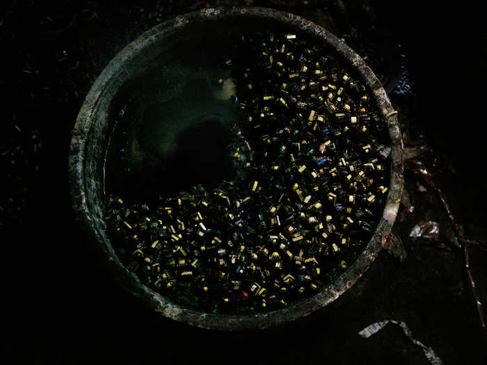 In Old Seelampur, New Delhi, India, a worker boils transformers and inductors in a metal pot in his home. Sometimes the work is carried out in the yard.