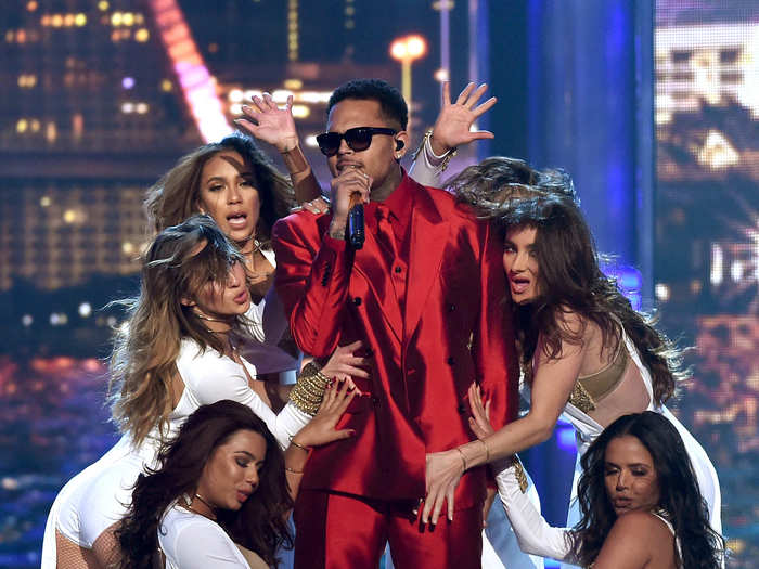 Chris Brown, in a shiny red suit, performed on stage with Pitbull.