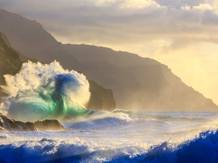 Giant waves crash together along the Na Pali Coast in Hawaii. "What really makes [this photo] special to me is the bird flying in the corner of the frame," says photographer Lee Scott.