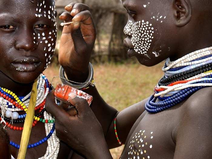 This photo was taken at a Karo village in the Omo Valley of Ethiopia. The Karo are famous for their skill in body painting. Photographer S. Ram found this "make-up artist" applying paint to a young woman with a Pointillism-like technique.