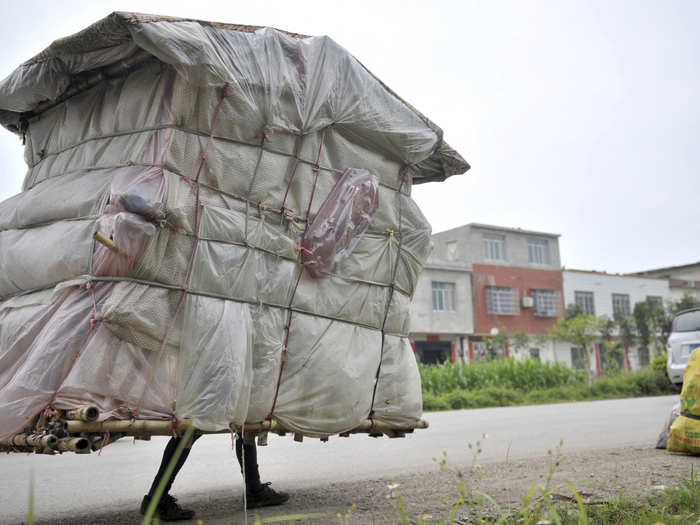 Liu Lingchao, 38, carries his makeshift dwelling as he walks along a road in Liuzhou, China in 2013. Five years ago, Liu decided to walk back to his hometown Rongan county in Guangxi from Shenzhen, some 462 miles away, where he once worked as a migrant worker. With bamboo, plastic bags and bed sheets, Liu made himself a five feet wide, six and a half feet high "portable room," weighing about 132 lb, to carry with him as he walked more than 12 miles a day.