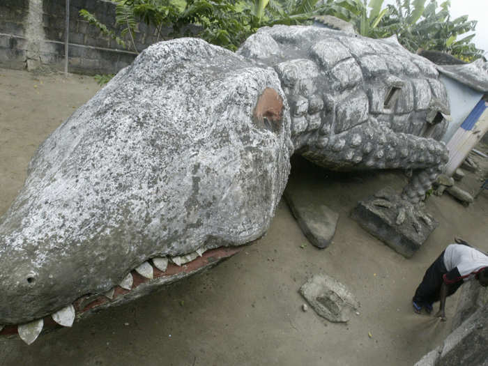 Below, Thierry Atta sweeps the courtyard of his house built in the shape of a crocodile in Ivory Coast