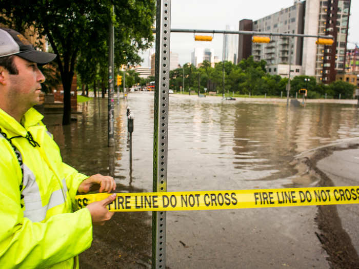 Police stretch tape across a flooded Sixth Street in the city on Monday after days of heavy rain.