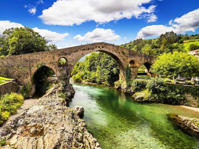 Cangas De Onis is situated on the banks of the Sella River in the northwestern region of Asturias, Spain. Sights include the Picos de Europa mountain range and the Puente Romano, which is one of the last bridges still standing from the Roman Empire.