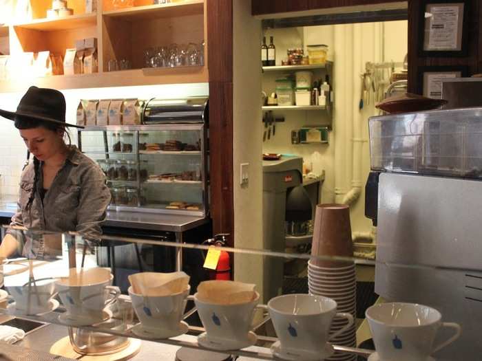 Behind the counter, baristas manage a drip bar that