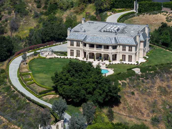 A manicured 5-acre lawn, huge snake-like driveway and a ginormous front gate surround the house.