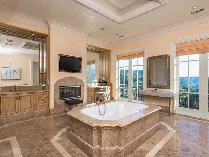 Each of the 15 bathrooms are also spacious. This one has a Jacuzzi in the center of the room and even TVs hung up on the wall.