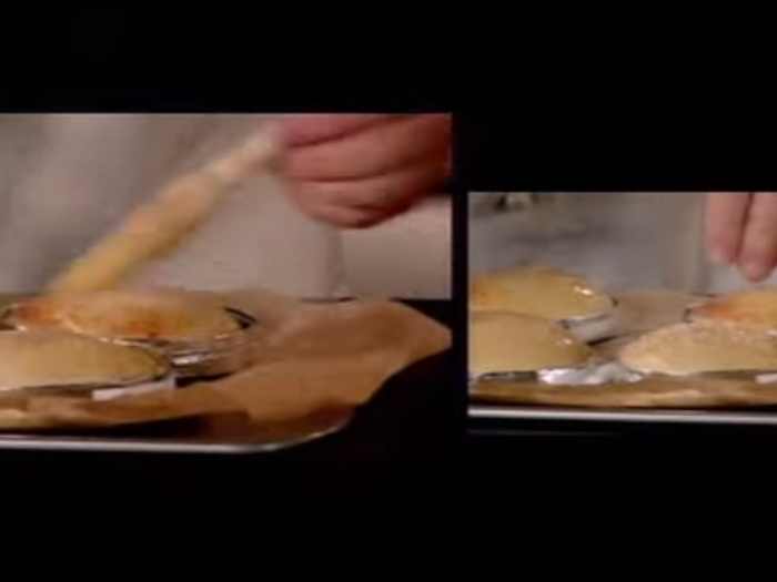 After several minutes, he removes the buns to glaze them with an egg mixture to improve their appearance and sprinkle them with sesame seeds. Then it