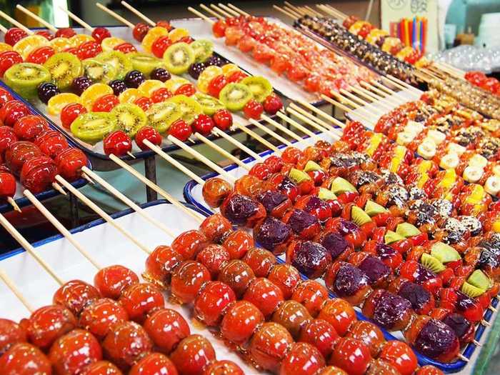 Tang hu lu is a sweet skewered snack made from various fruits like strawberry, kiwi, oranges, bananas, and grapes coated in hard sugar. You’ll see peddlers in Shanghai, China, offering them throughout the day.