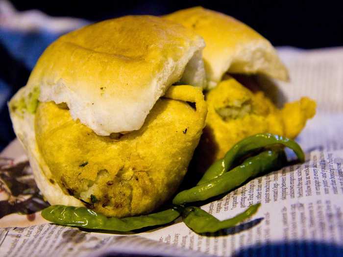 Vada Pav is served in street stalls and restaurants throughout India. The dish consists of boiled and spiced mashed potatoes that are coated in flour and deep fried. Then, the mixture is stuffed in a bread bun and served with chutneys.