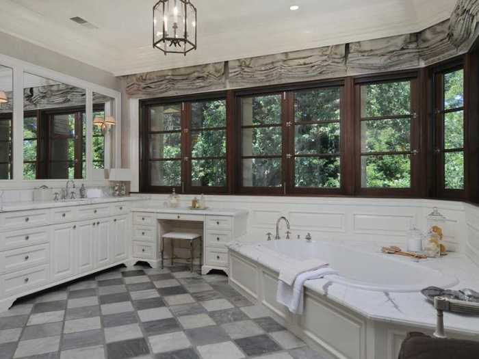 The master bathroom has a tub for two and a view of the grounds.