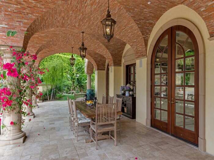 Columns are wrapped with flowers, and space abounds for all the patio furniture you can buy.